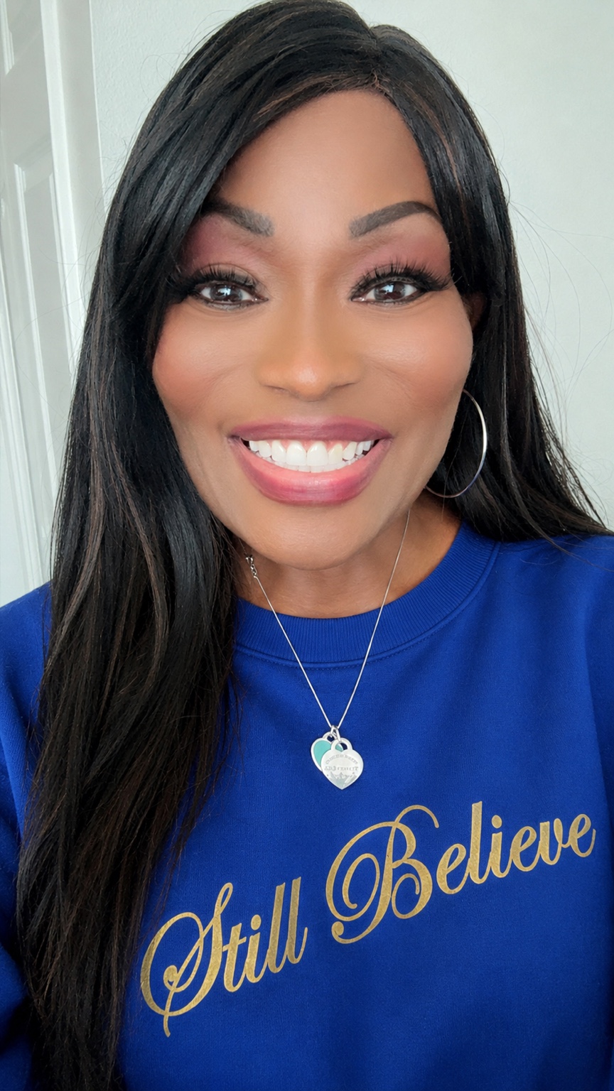 Dr. Felicia Banks wearing the royal-blue Still Believe sweatshirt