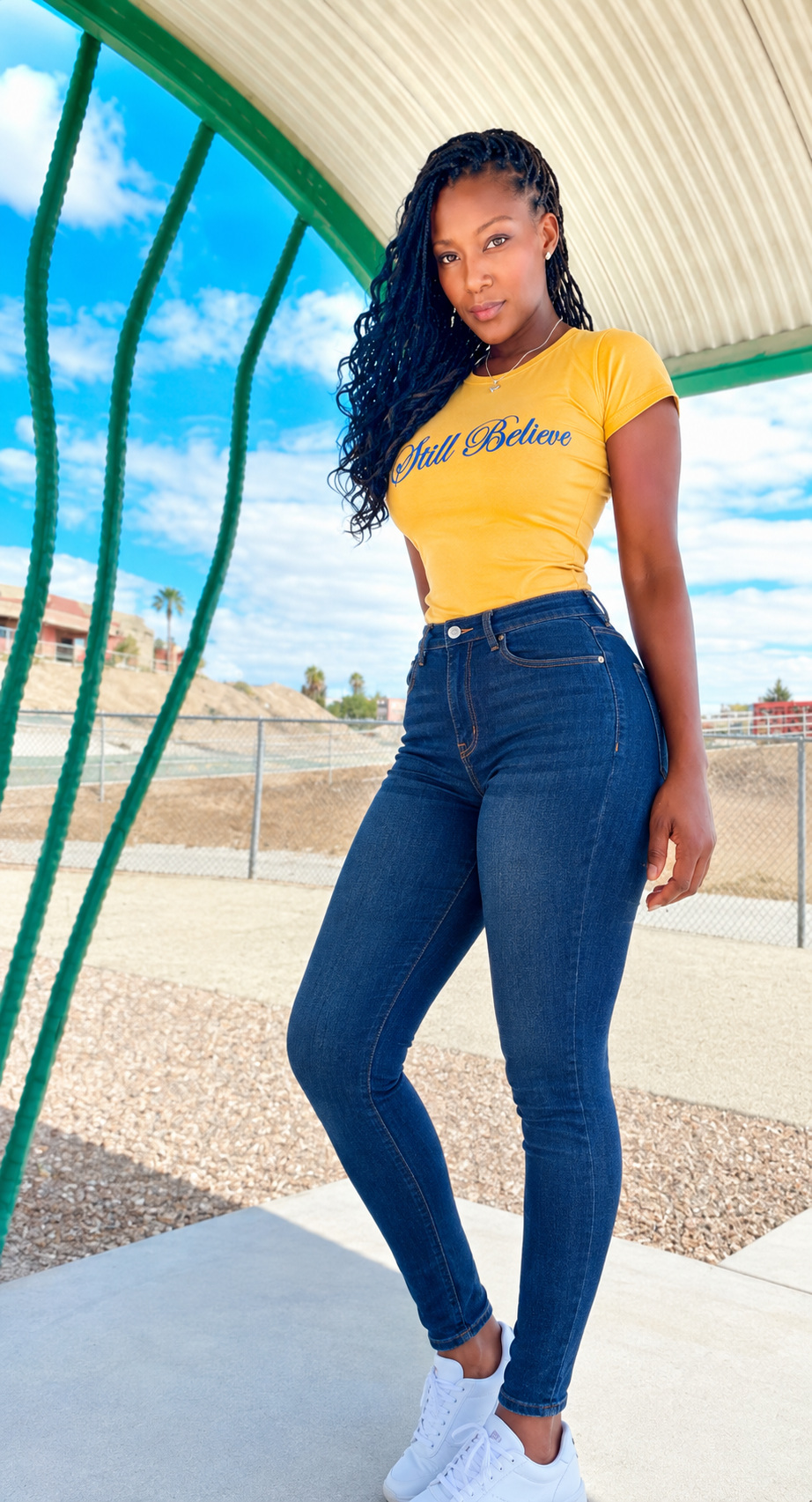 Model wearing the yellow Still Believe T-shirt with jeans